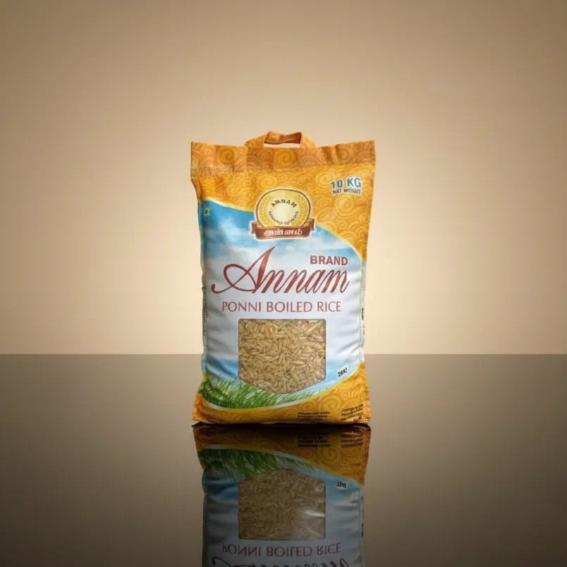 Bag of Brand Annam Ponni Boiled Rice on a reflective surface with a beige background