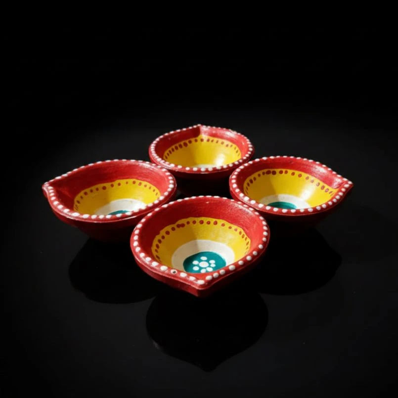 Four red and yellow ceramic bowls on a black background