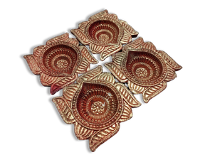 Set of four terracotta oil lamps with floral patterns.
