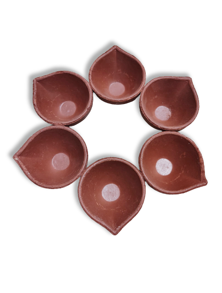 A set of six red clay Diya (oil lamp) holders arranged in a circle.
