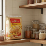 Aashirvaad Atta with Multigrains package on a kitchen shelf with jars of grains.