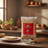 Aashirvaad Atta bag on a kitchen counter with flour, rolling pin, and vegetables in the background