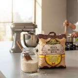 Anjappar Sona Masoori Rice package on a kitchen counter with a jar of rice and a mixer in the background.