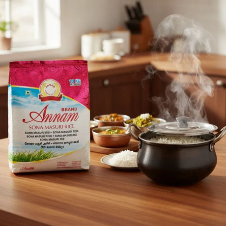 Annam brand Sona Masuri rice package on a kitchen counter with steaming pots and bowls of food.