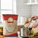 Person measuring rice into a pot with a bag of rice labeled 'Annan' in the foreground.