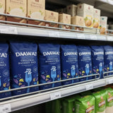 Shelf with blue packages of DAAWAT Original Basmati Rice and other branded products.