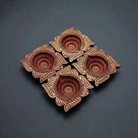 Decorative ceramic diyas with floral patterns on a dark background